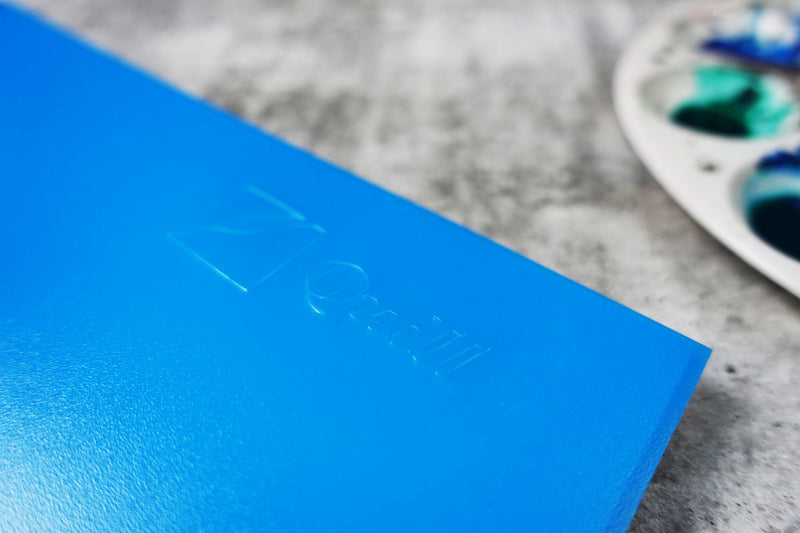 Close view of the Quill Visual Art Diary A4 Marine Blue cover corner showing the embossed Quill logo on the textured polypropylene