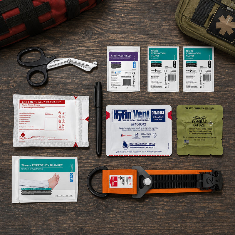 Complete RapidStop Medium Bleed Control Kit arranged neatly on a timber surface. Visible equipment includes QuikClot Combat Gauze, RapidStop tourniquet, HyFin Vent Compact chest seal twin pack, 4 inch emergency trauma bandage, thermal emergency blanket, CPR faceshield, two nitrile examination glove packs, trauma shears and marker for organised trauma preparedness.