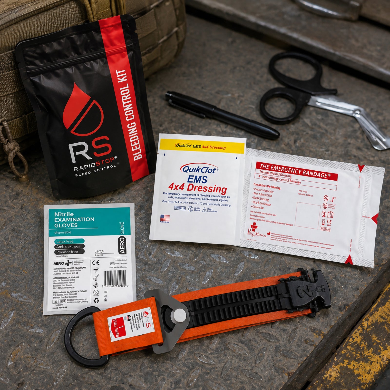 RapidStop emergency bleeding control equipment presented on an industrial metal surface beside a field bag. The QuikClot EMS 4x4 Dressing and emergency trauma bandage are positioned with nitrile gloves, trauma shears, marker, RapidStop tourniquet and compact black bleeding control pouch.