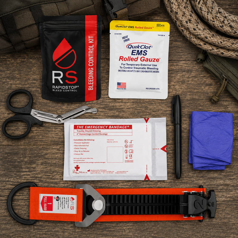 Complete RapidStop Bleed Control Small Pack arranged on a timber surface, displaying the RapidStop tourniquet, QuikClot EMS Rolled Gauze, 4 inch emergency trauma bandage, universal trauma shears, marker, examination gloves and RapidStop bleeding control kit pouch.