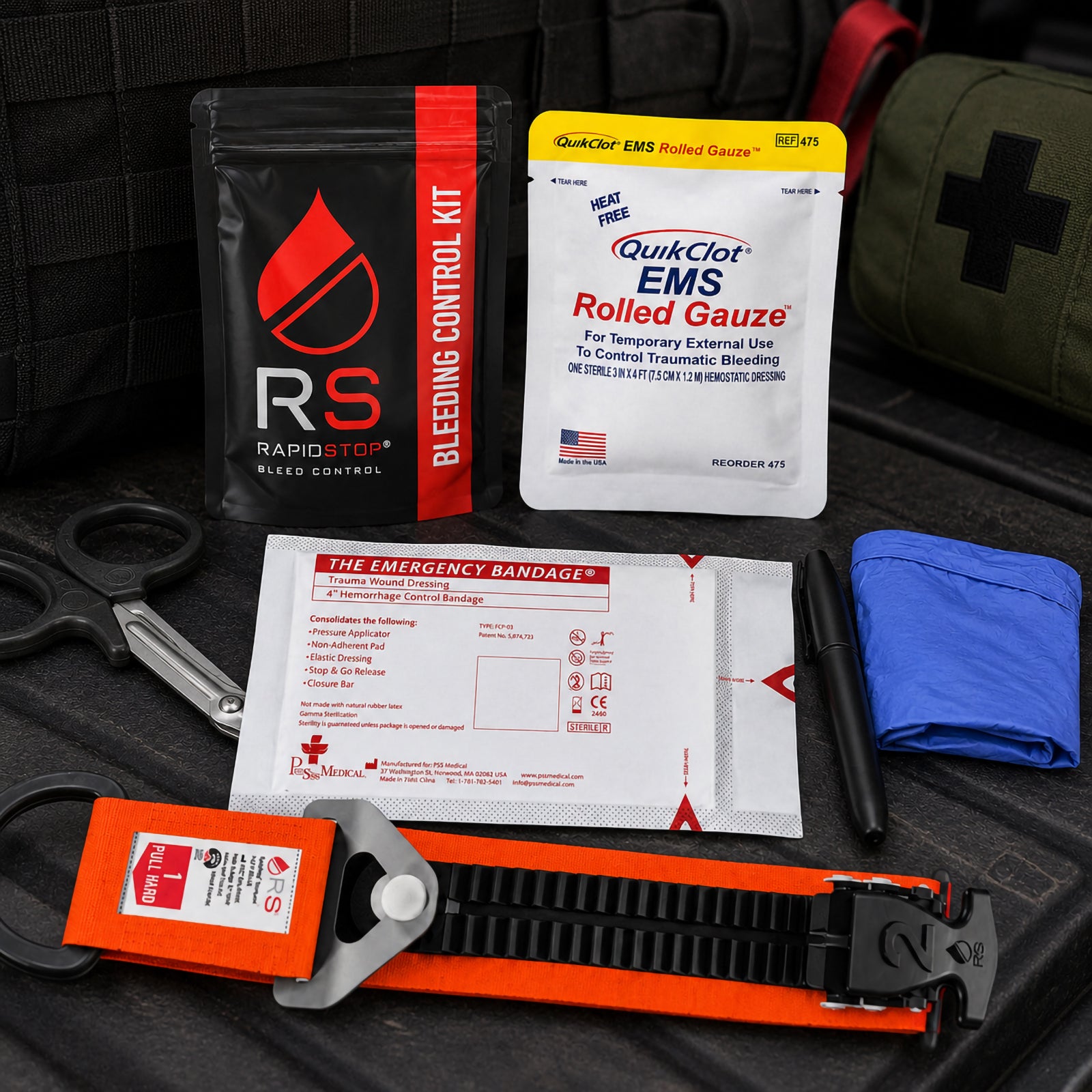 RapidStop emergency bleeding control components displayed on dark tactical equipment, including the orange RapidStop tourniquet, QuikClot EMS Rolled Gauze, packaged trauma wound dressing, trauma shears, black marker, blue examination gloves and RapidStop kit pouch.