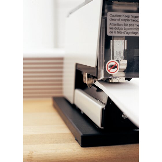 Close-up of the Rapid 105E stapling head behind its clear visor, with a caution label to keep fingers clear