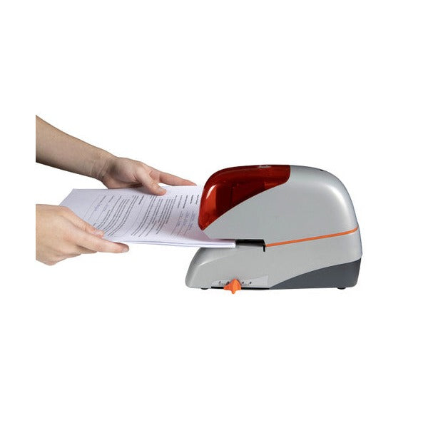 Hands sliding a stack of printed pages into the front slot of the Rapid 5080E electric stapler