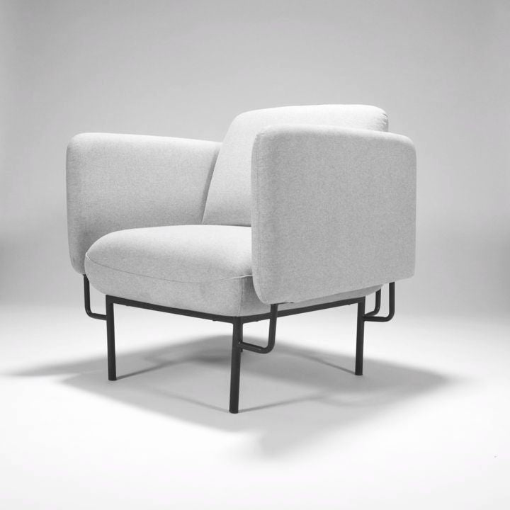 Rapidline Capri one seater lounge in light grey fabric from a side angle, showing the arm height and black steel legs.