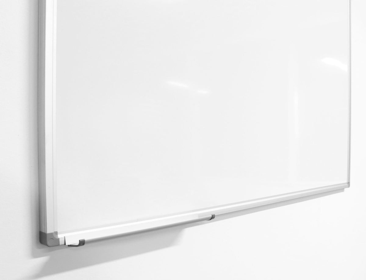 Close-up of the Rapidline Porcelain Whiteboard lower corner, showing the aluminium frame, grey corner cap and the end of the pen tray.