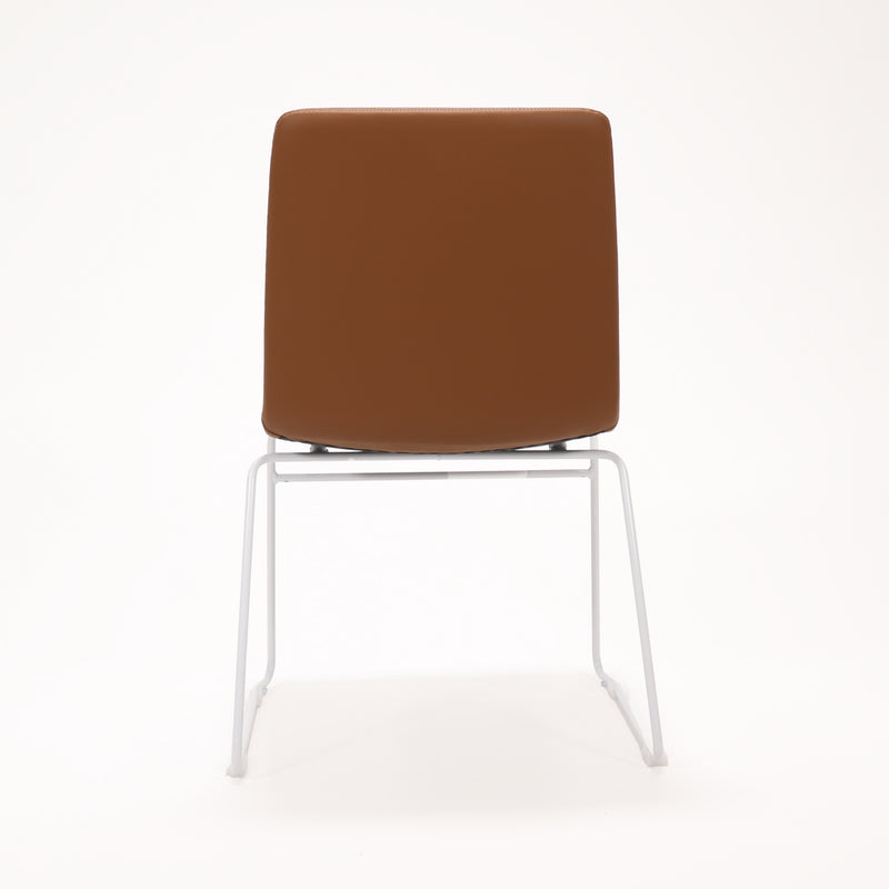 Rapidline Pixel sled base visitor chair in amber PU on a white powdercoated continuous sled base, product photograph on a plain background showing the ribbed horizontal stitching across the seat and back.
