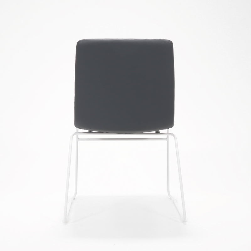 Rapidline Pixel sled base visitor chair in French Navy PU on a white powdercoated continuous sled base, product photograph on a plain background showing the ribbed horizontal stitching across the seat and back.