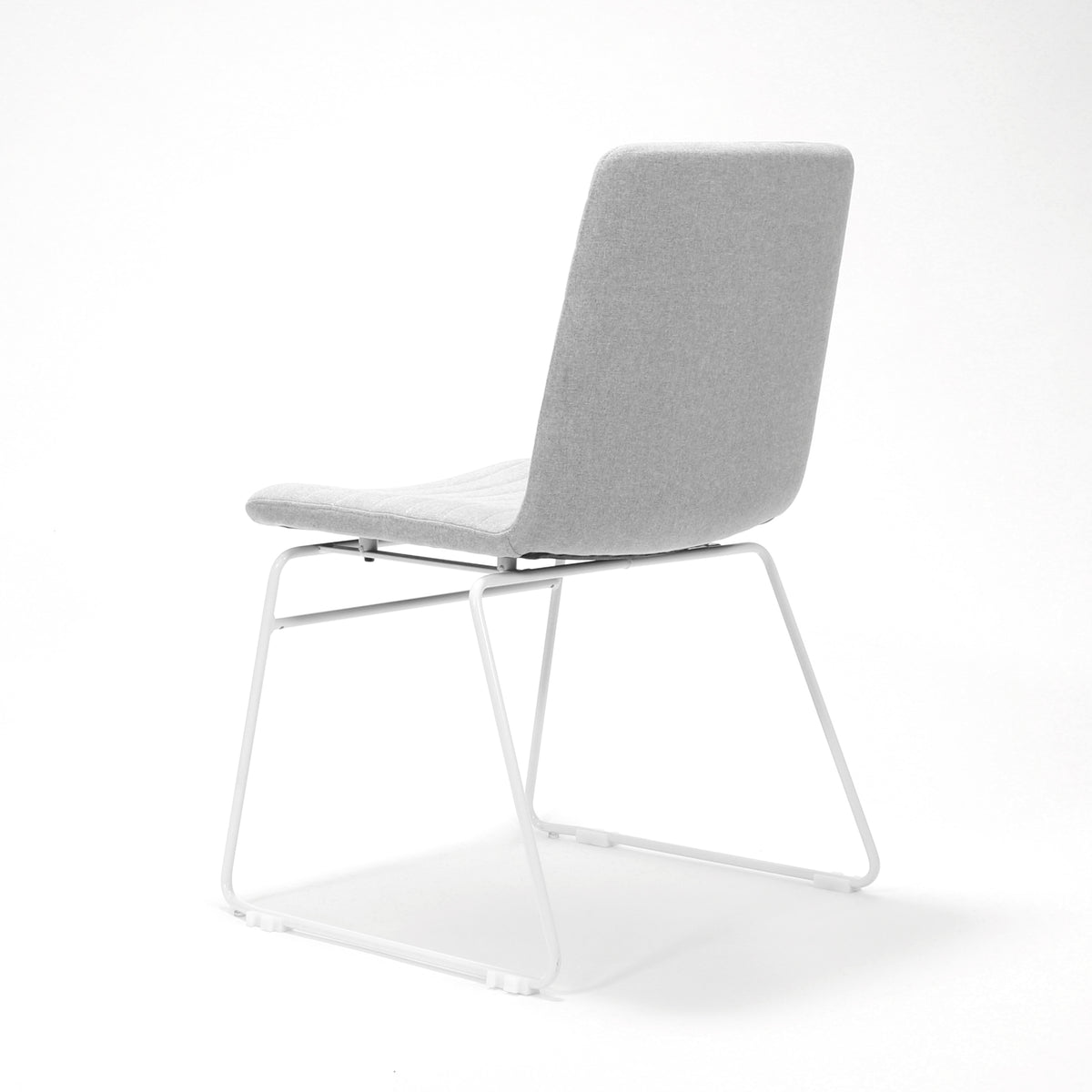 Rapidline Pixel sled base visitor chair in light grey commercial fabric on a white powdercoated continuous sled base, product photograph on a plain background showing the ribbed horizontal stitching across the seat and back.
