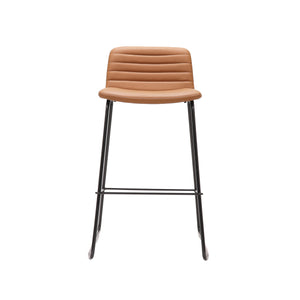 Rapidline Pixel bar high stool in amber PU on a black powdercoated tall sled base with a foot rail, product photograph on a plain background showing the ribbed horizontal stitching across the seat and back.