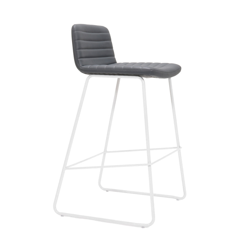 Rapidline Pixel bar high stool in French Navy PU on a white powdercoated tall sled base with a foot rail, product photograph on a plain background showing the ribbed horizontal stitching across the seat and back.