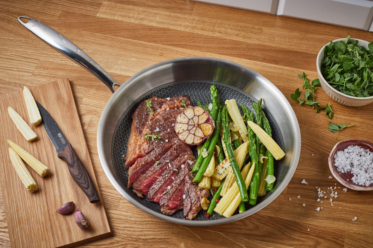 Resto Achird frypan in use, cooking steak with vegetables on the honeycomb non-stick surface