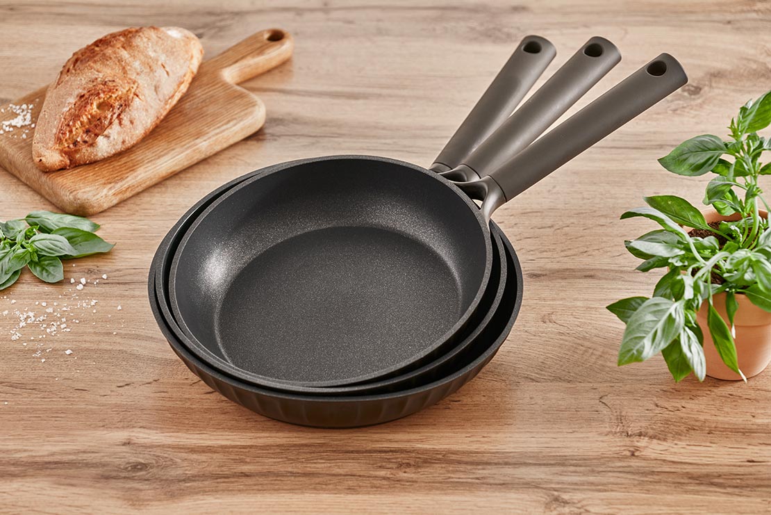 Three Resto Ascella frypans stacked one on top of another, showing the range in its single dark finish (Resto series image)