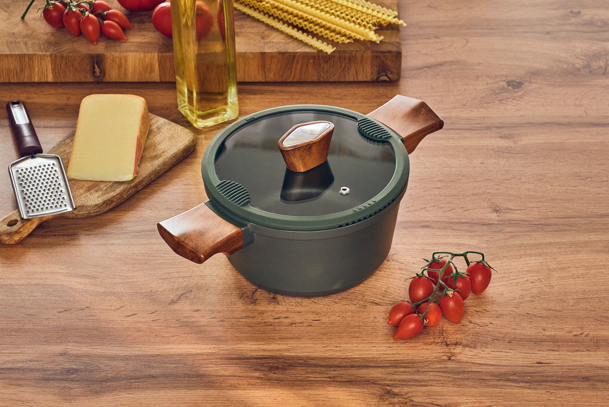 A Resto Sadr casserole with its glass lid on a table, showing the dark green exterior (Resto lifestyle image)