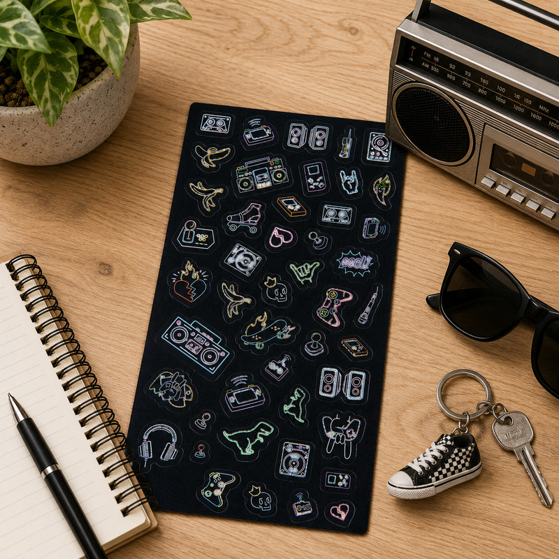 Full Retro Glow sticker sheet arranged beside sunglasses, keys and a vintage radio. The collection features nostalgic designs such as cassette tapes, arcade controls, headphones, skateboards and retro electronics.