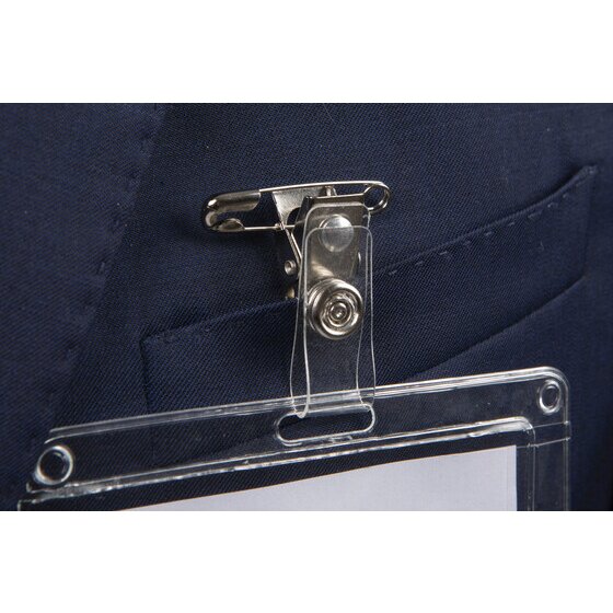 Rexel badge clip in use on a navy shirt pocket, the metal clip and safety pin fastened through the fabric with a clear card holder hanging from the strap.