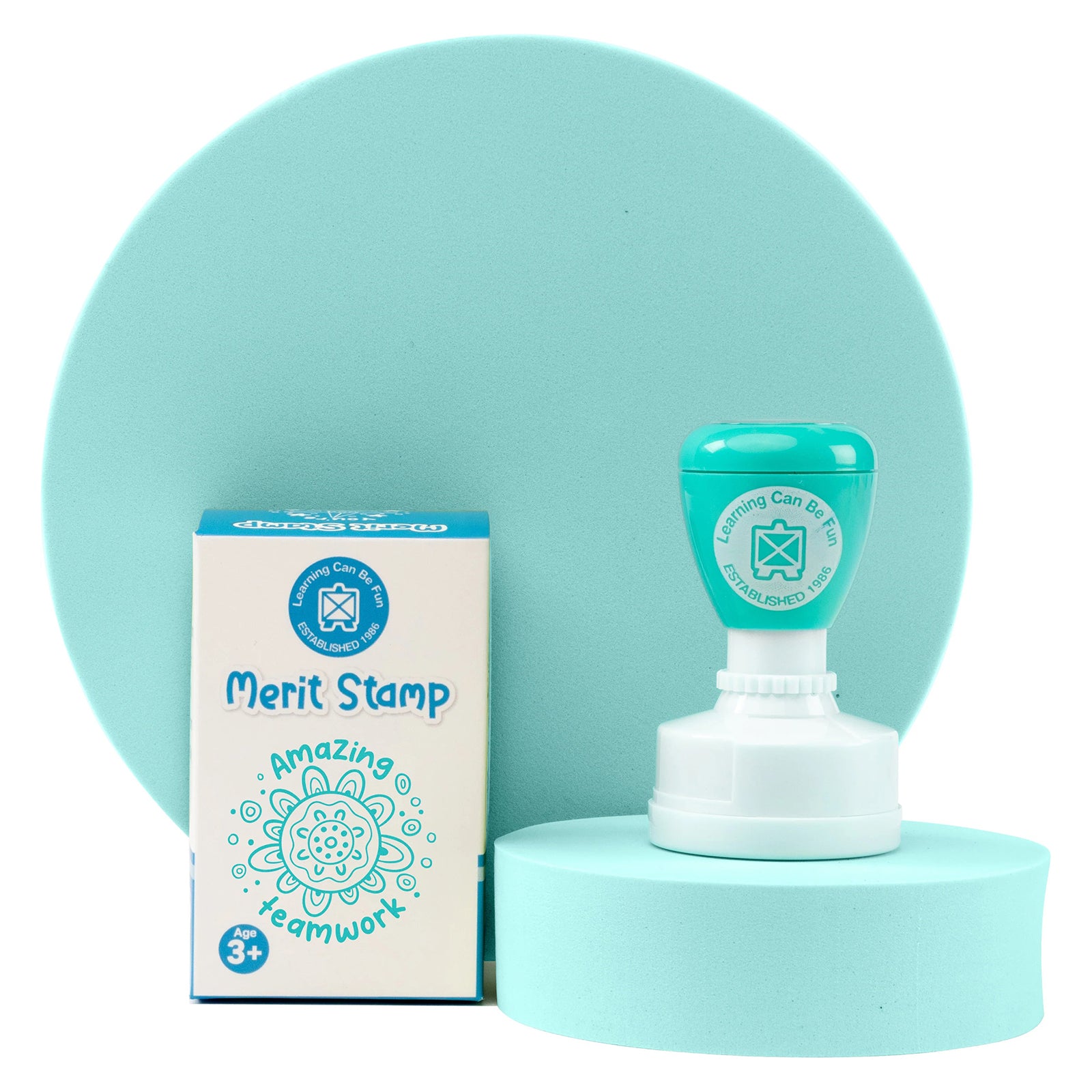The stamp and retail packaging are presented on a display stand with coordinating colours that reflect the Sacred Country theme. The image showcases the product's design, packaging details and strong visual appeal for educators seeking meaningful recognition tools.