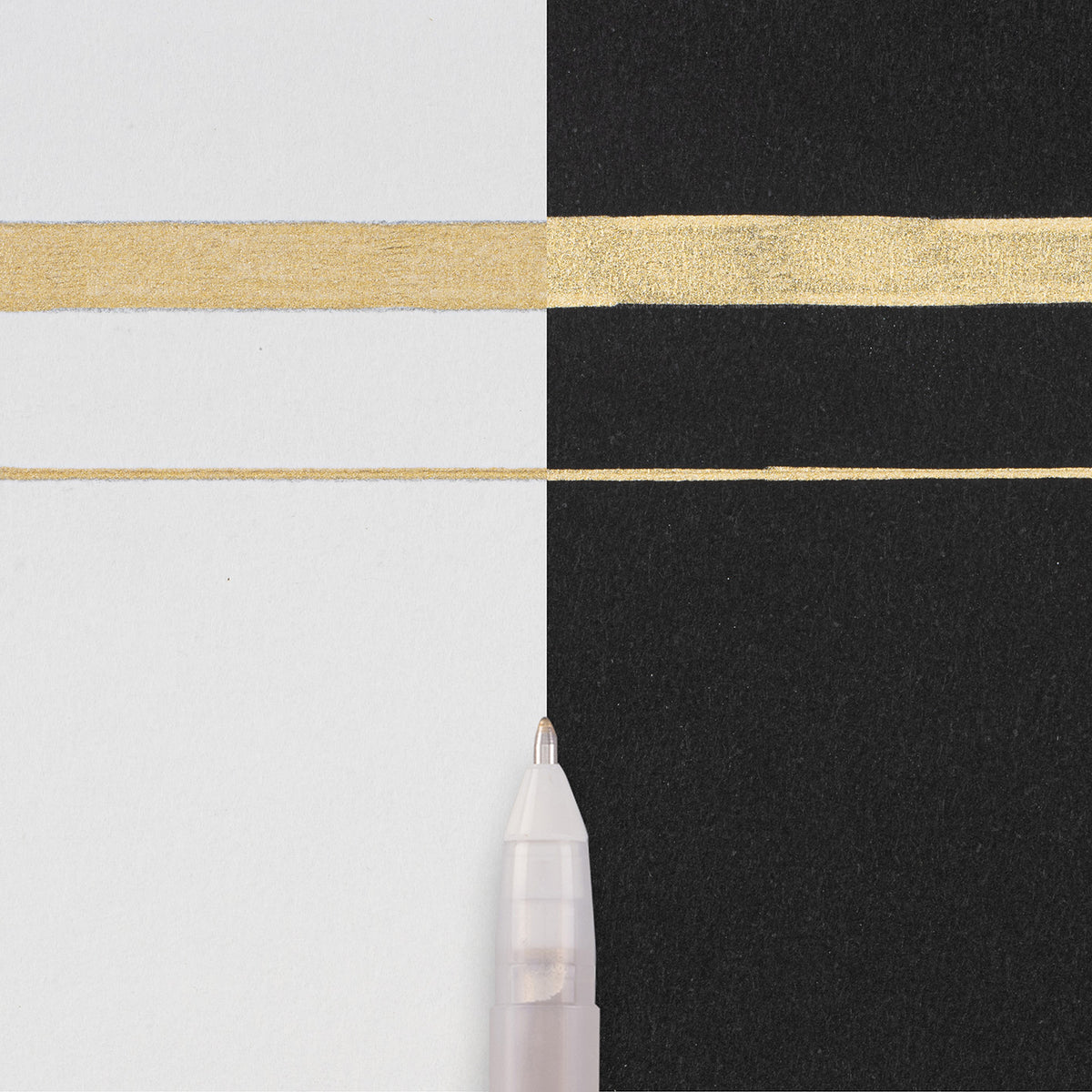 Sakura Gelly Roll Metallic Gold writing sample: thick and thin metallic lines across white and black paper with the pen tip below