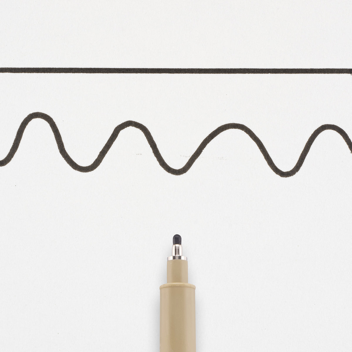 Sakura Pigma Micron 12 Black: needle tip below a straight and a wavy 0.70mm test line drawn on white paper