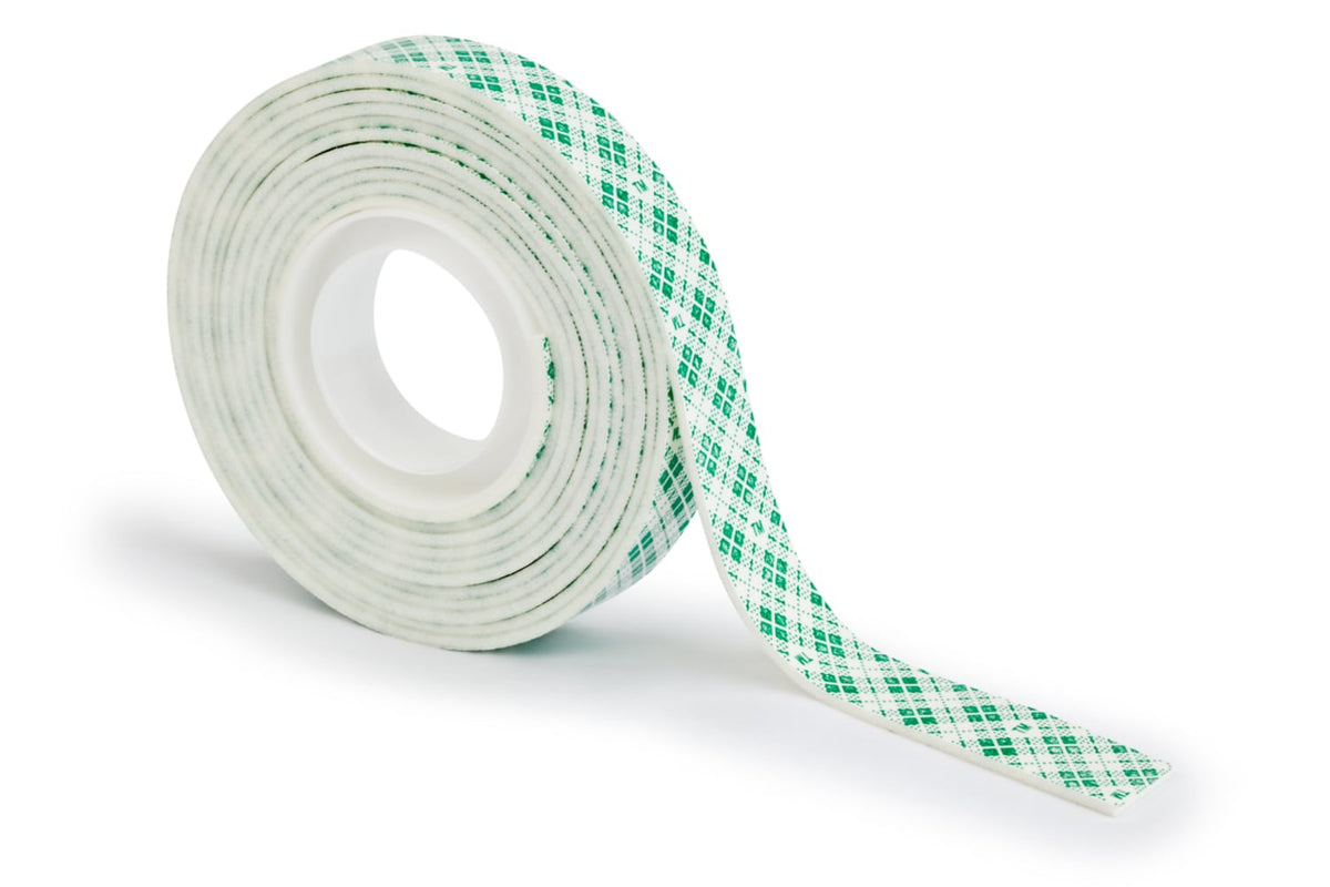 Roll of white Scotch indoor foam mounting tape partly unrolled, showing the green and white chequered liner