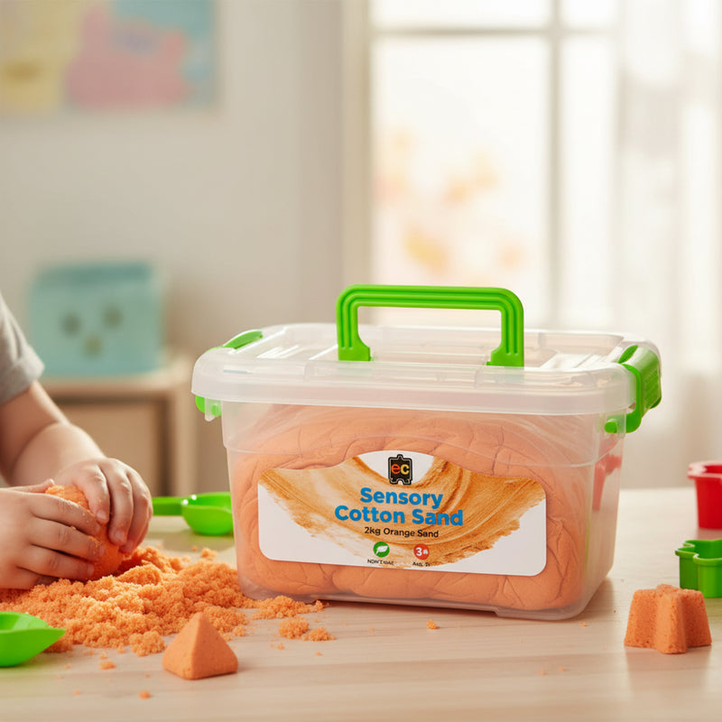 Educational Colours Sensory Cotton Sand 2kg Orange displayed in storage container while child moulds and shapes the soft textured sand using sensory play tools.