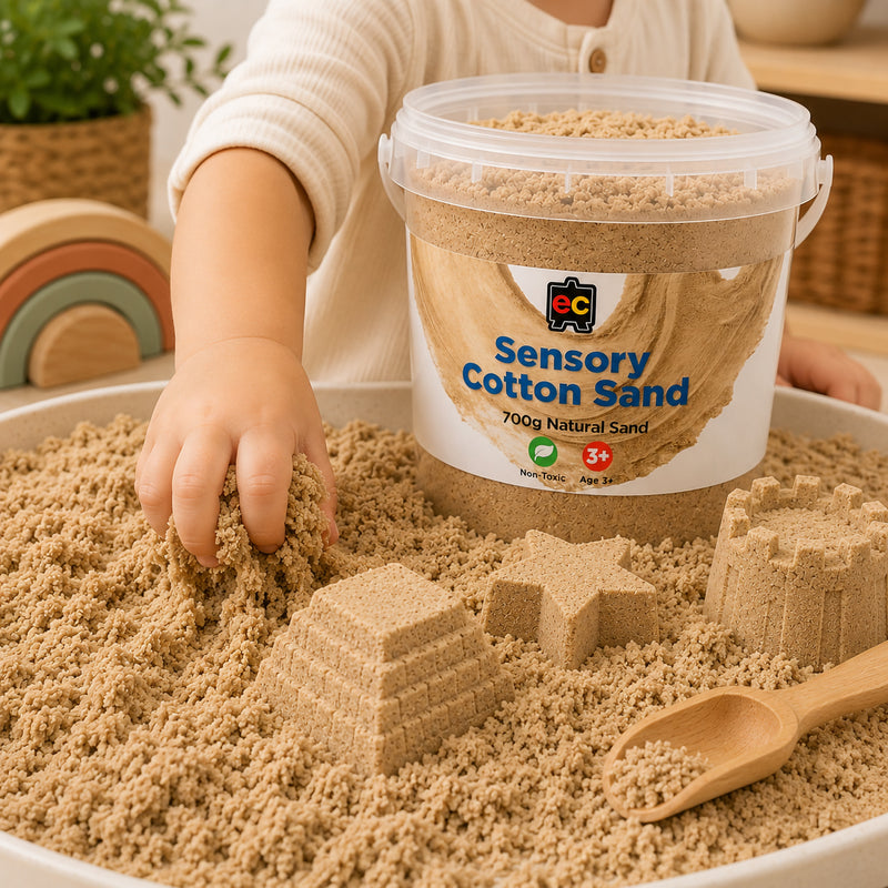Child exploring natural sensory cotton sand with hands while creating textured shapes beside Educational Colours reusable storage tub.
