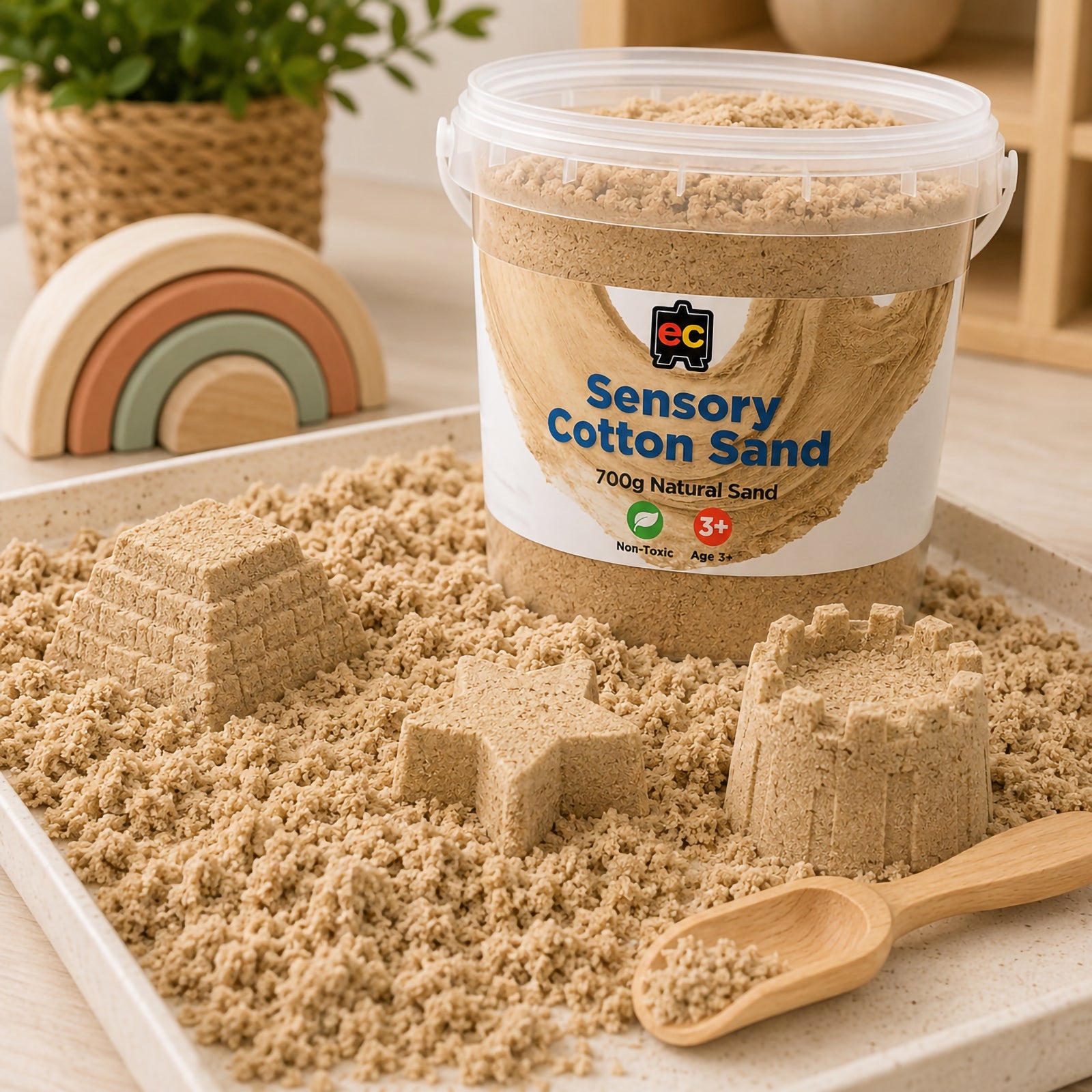 Natural coloured sensory cotton sand displayed in a tray with moulded castles, star shapes, and wooden scoop for tactile play activities.