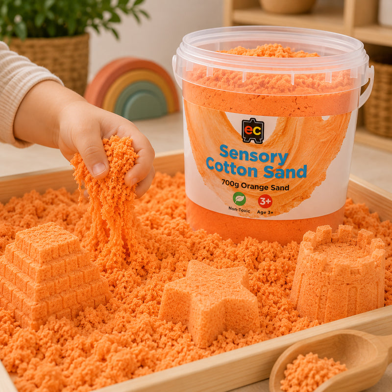 Child stretching and pouring vibrant orange sensory cotton sand while creating moulded shapes beside Educational Colours reusable storage tub.