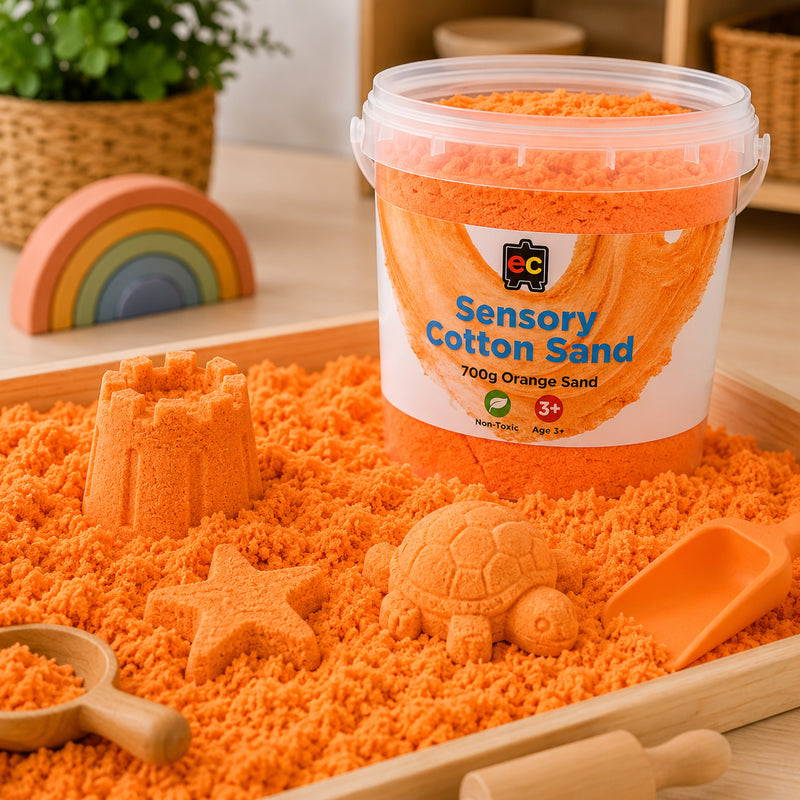 Orange sensory cotton sand displayed in a wooden sensory tray with moulded castle, turtle, and star shapes for imaginative tactile play.