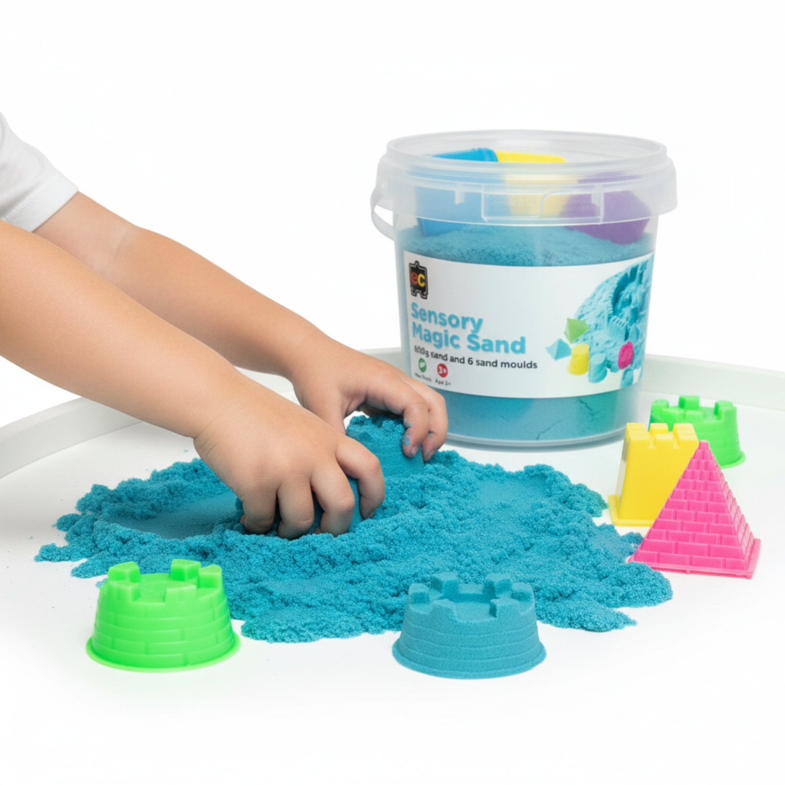 Child exploring Educational Colours Sensory Magic Sand with Moulds 600g Blue while shaping bright blue sensory sand beside colourful mould accessories and reusable storage tub.