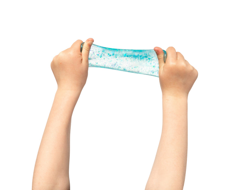 A hand squeezing the glitter ball out of shape, showing how far the material stretches before returning to a ball.