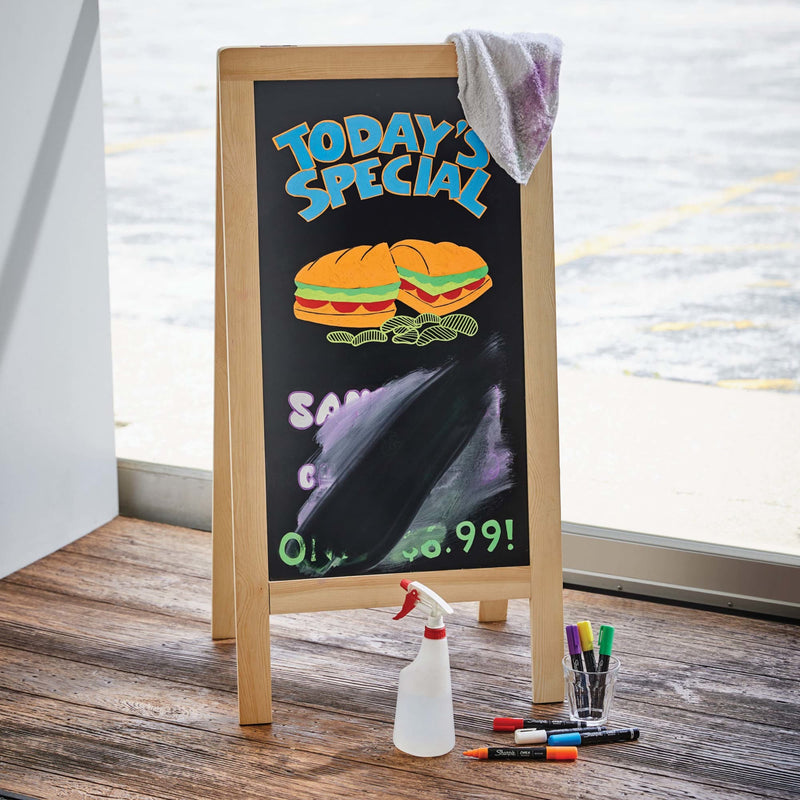 A-frame sandwich board reading Today's Special written with Sharpie Chalk markers, with a spray bottle beside it.