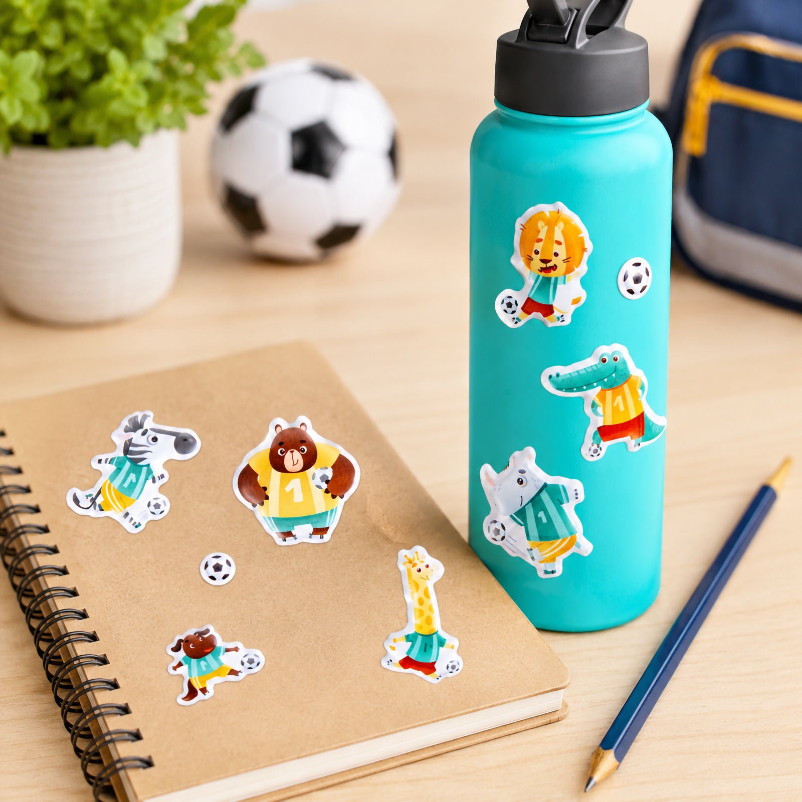 Turquoise drink bottle and notebook decorated with Soccer Stars puffy stickers featuring animal soccer players including a lion, bear, crocodile, giraffe and zebra. The colourful stickers add a playful sporting theme to everyday school and personal items.