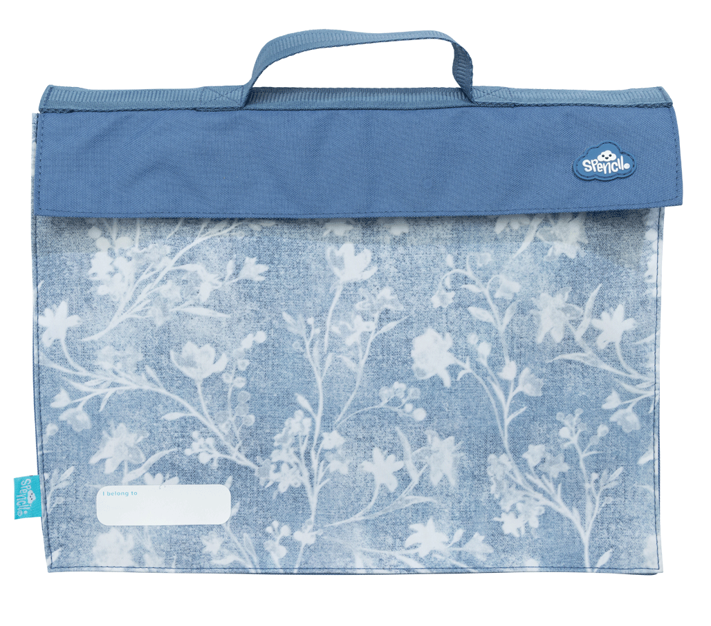 Front of the Spencil Denim Daze library bag showing faded blue denim texture with pale botanical sprigs and a mid-blue flap, with the top carry handle, fold-over flap and white name pocket at the lower left