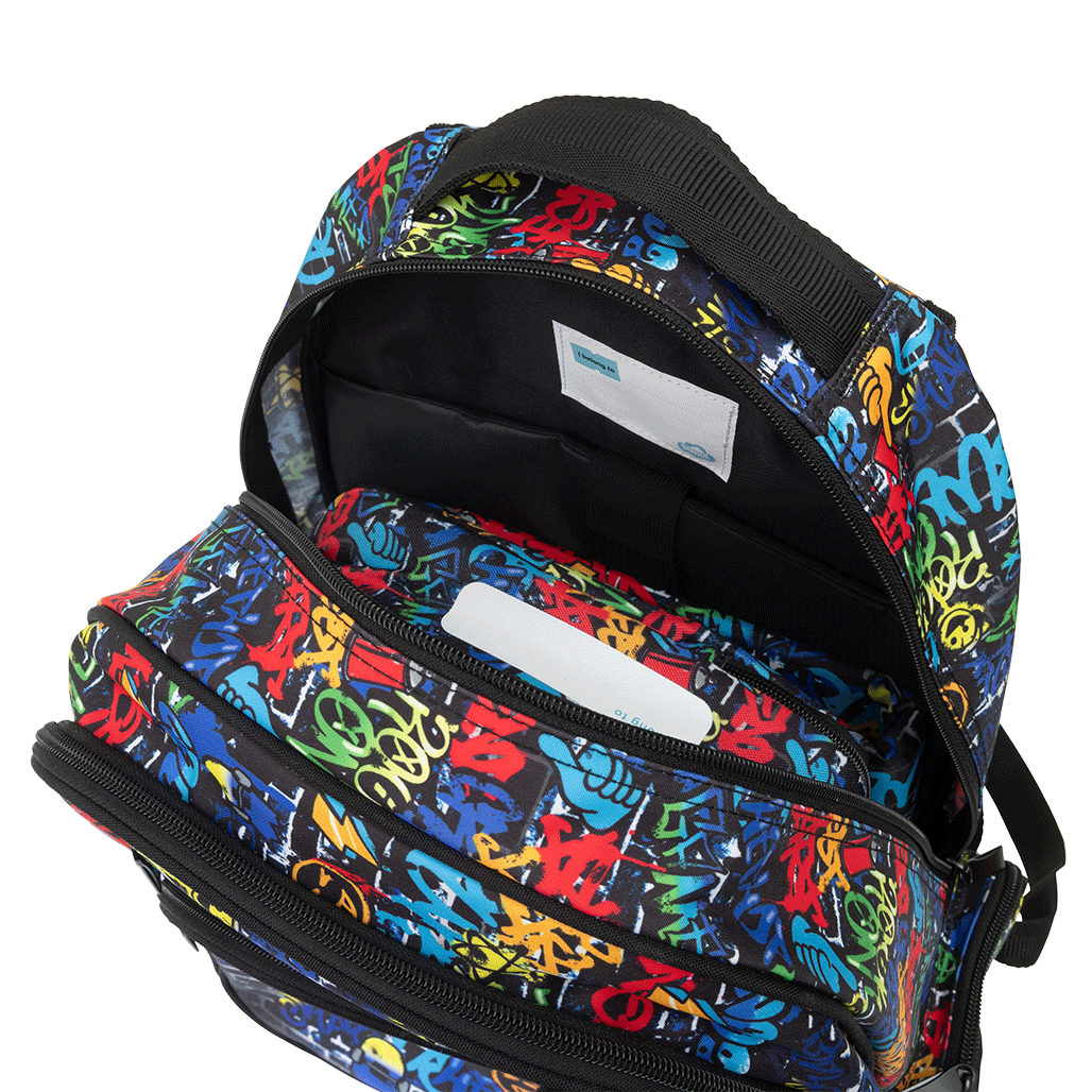 Spencil Tag Street Big Kids Backpack, open main compartment showing the padded device sleeve, multicoloured graffiti lettering on a dark brick wall