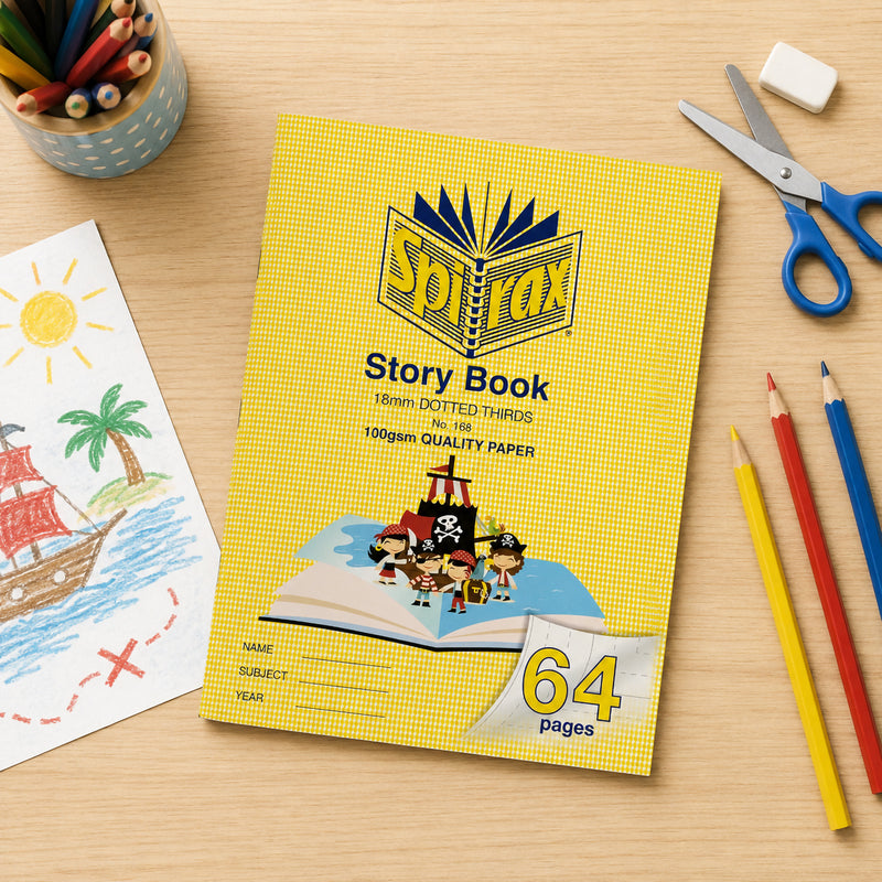 Top view of the Spirax 168 Story Book on a wooden desk surrounded by coloured pencils, scissors, eraser and a child's pirate drawing, showcasing an engaging literacy and art learning environment.