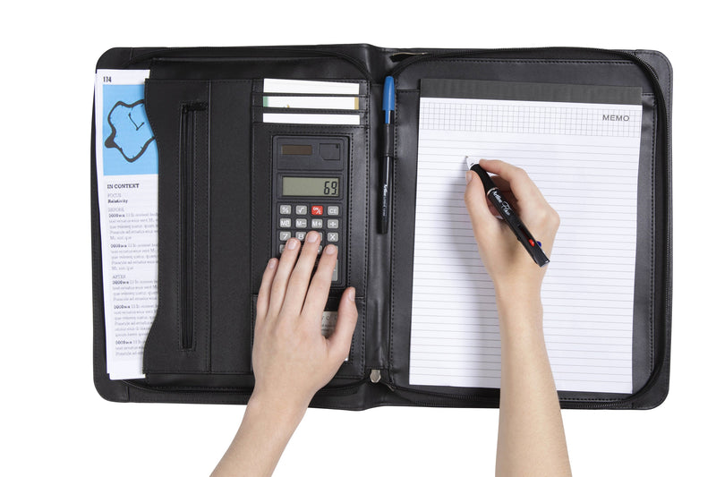 Person using the calculator on the left flap of the open Spirax executive compendium while writing on the memo pad on the right