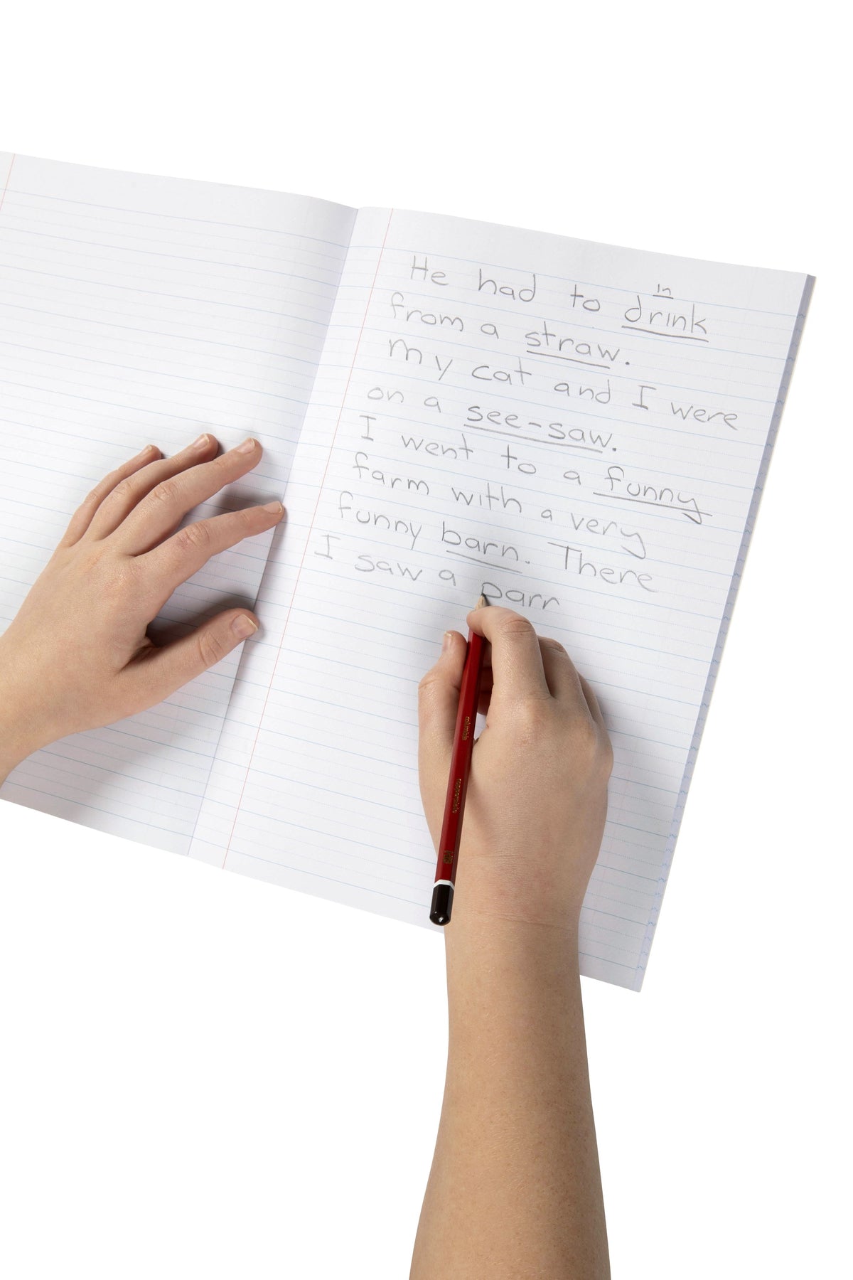 Child writing sentences in pencil on the 18mm dotted thirds lines of an open Spirax 117 A4 exercise book, one hand resting on the left page
