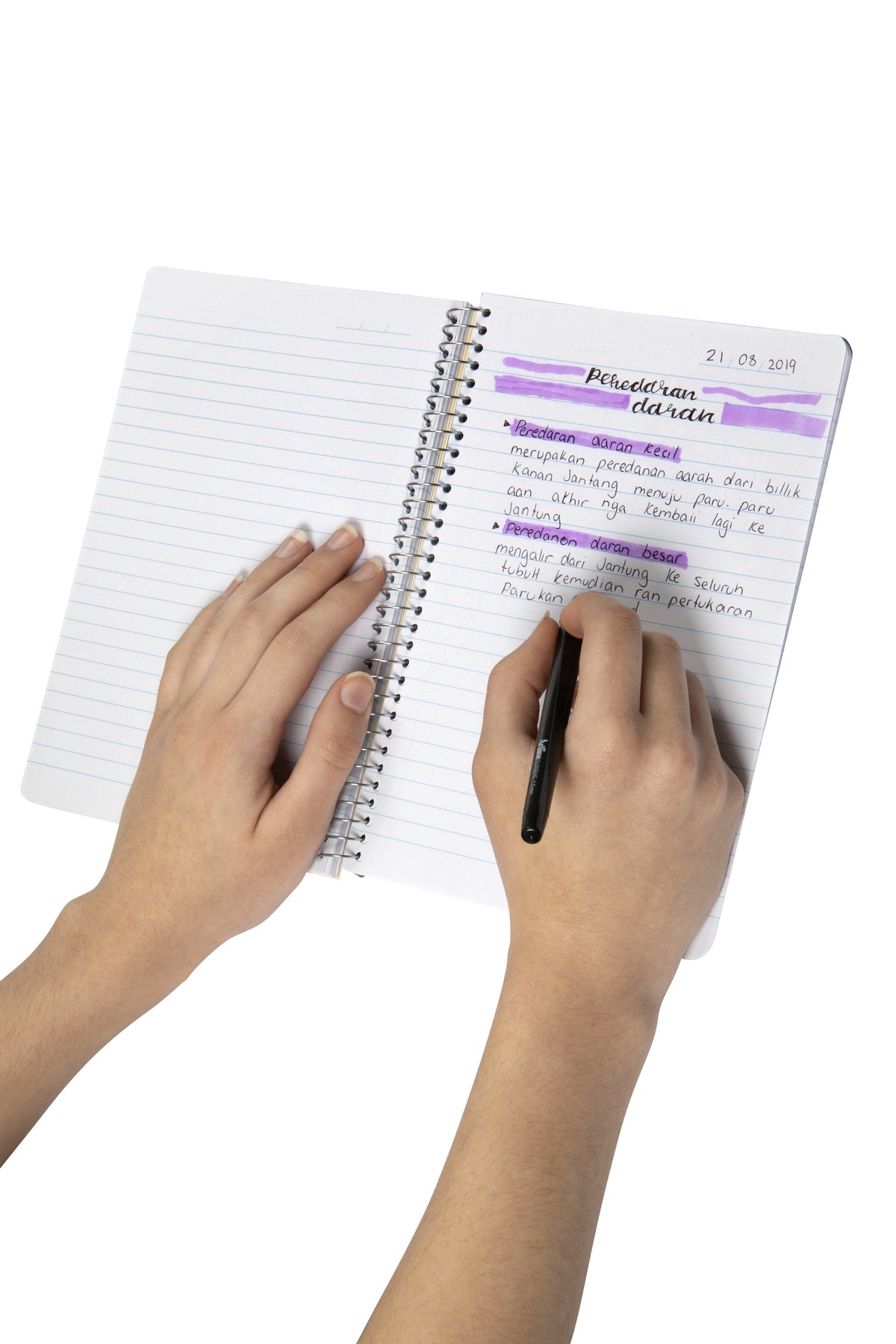 Hands writing highlighted study notes on a ruled page of a Spirax Kode A5 note book with silver wire binding
