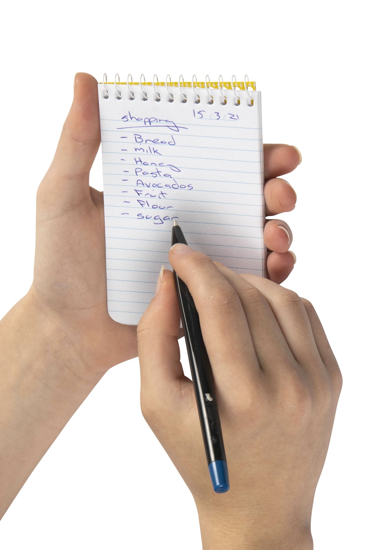 Spirax No. 560 pocket note pad held in one hand with a handwritten shopping list on the ruled page and a pen in the other hand