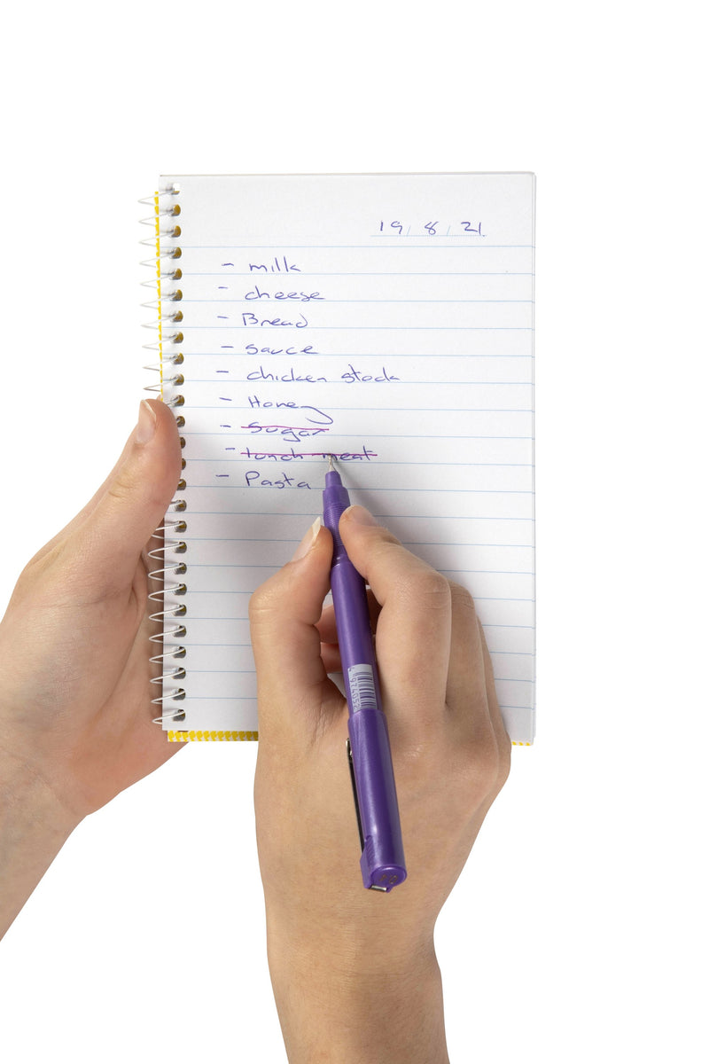 Spirax No. 564 side opening notebook held in one hand with a handwritten list in purple pen on the ruled page