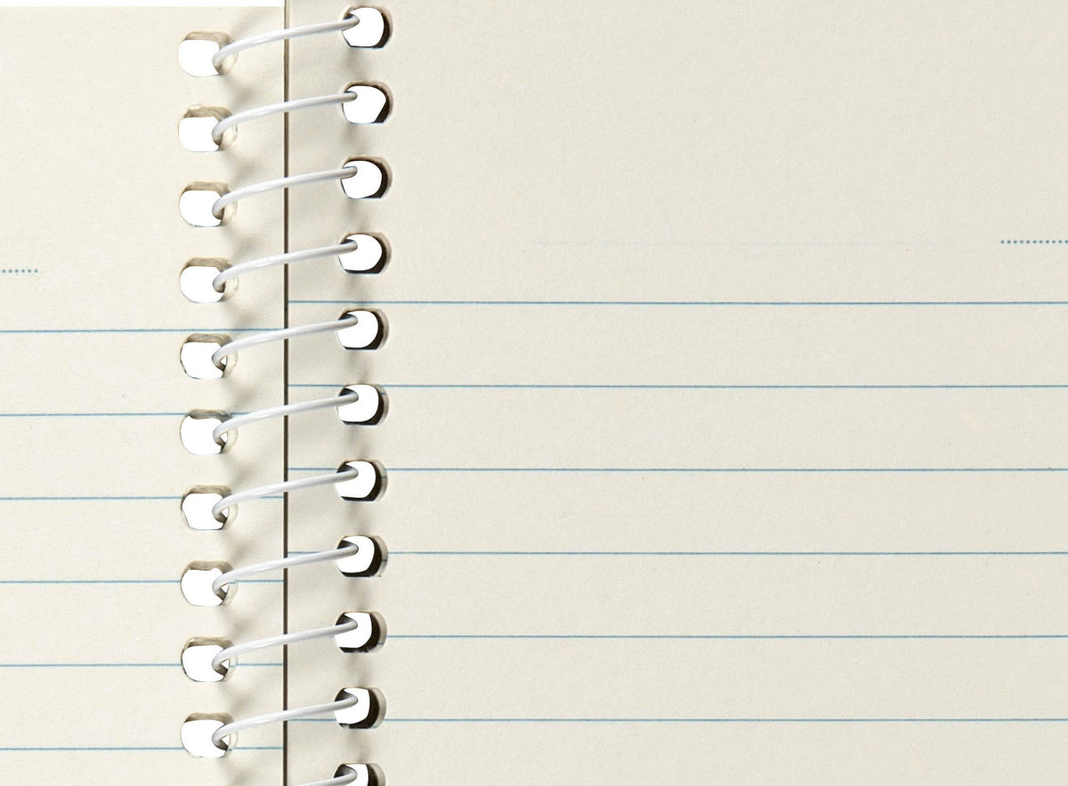 Close-up of Spirax 813 ruled lines next to the white spiral, showing the dotted date line across the top of the small page