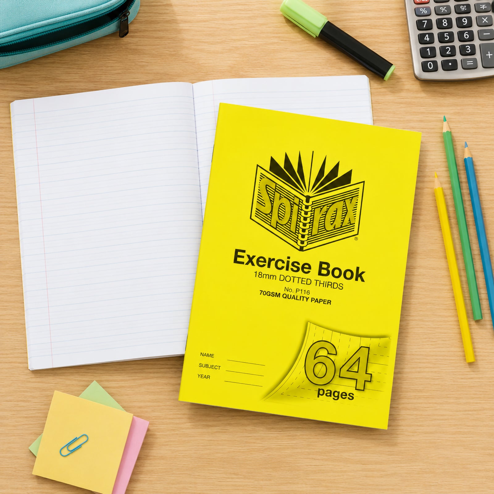 Top view of the Spirax P116 A4 64 page exercise book placed beside an open notebook, calculator, coloured pencils, highlighter and pencil case, creating a practical classroom study workspace for primary students.