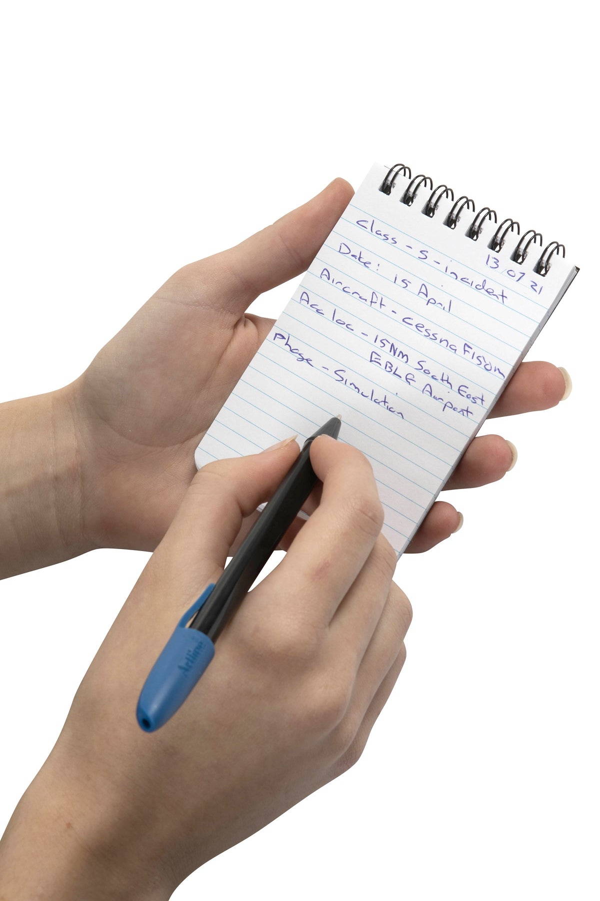 Spirax P560 pocket note pad held in the hand while handwritten notes are added in blue pen to its ruled page, black twin wire across the top