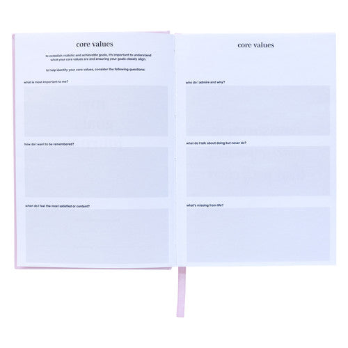 Spirax goals journal open at two core values pages with printed questions and shaded boxes for written answers