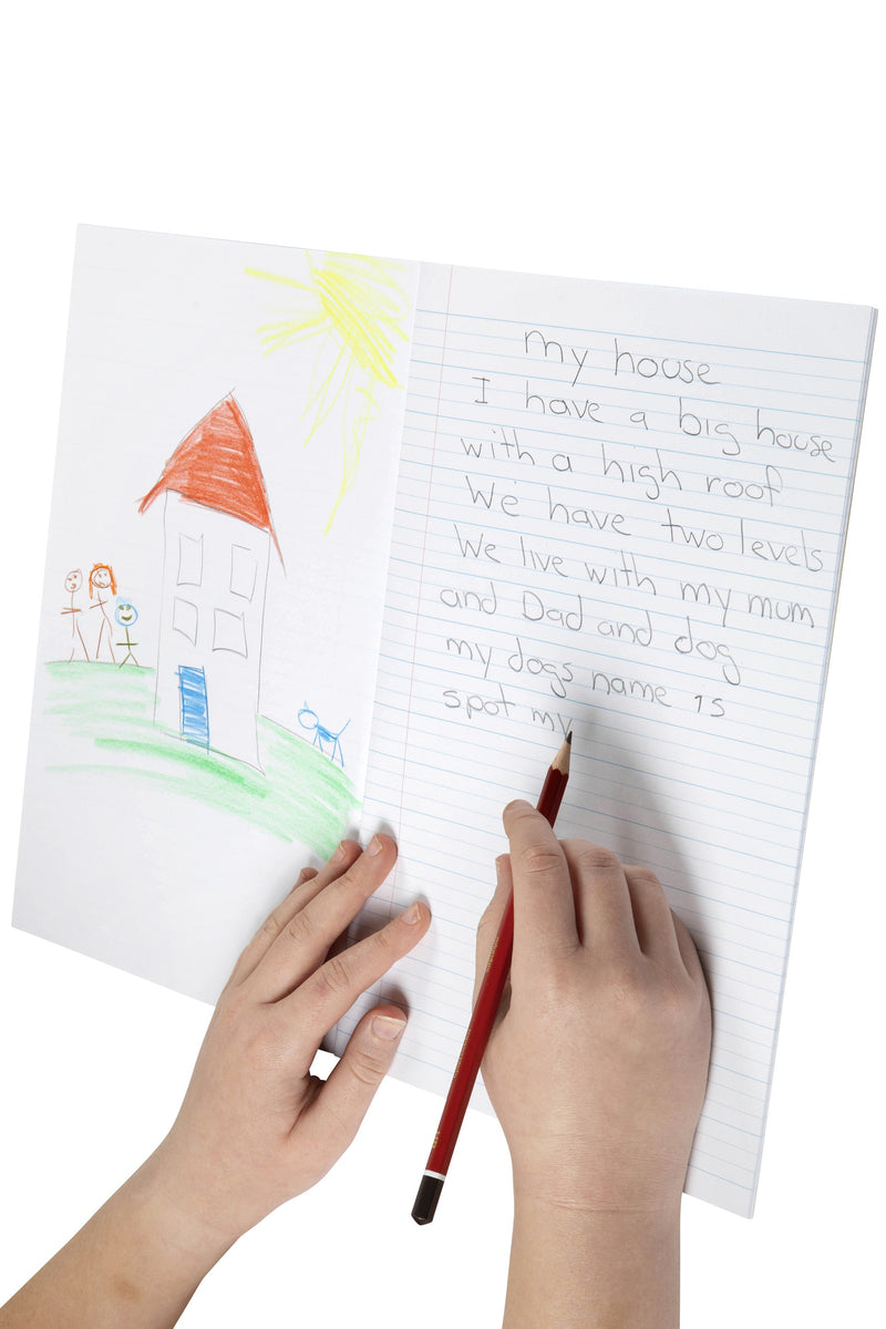Child writing a short story in pencil on the dotted thirds page of a Spirax 142 project book, with a crayon drawing of a house on the blank page opposite