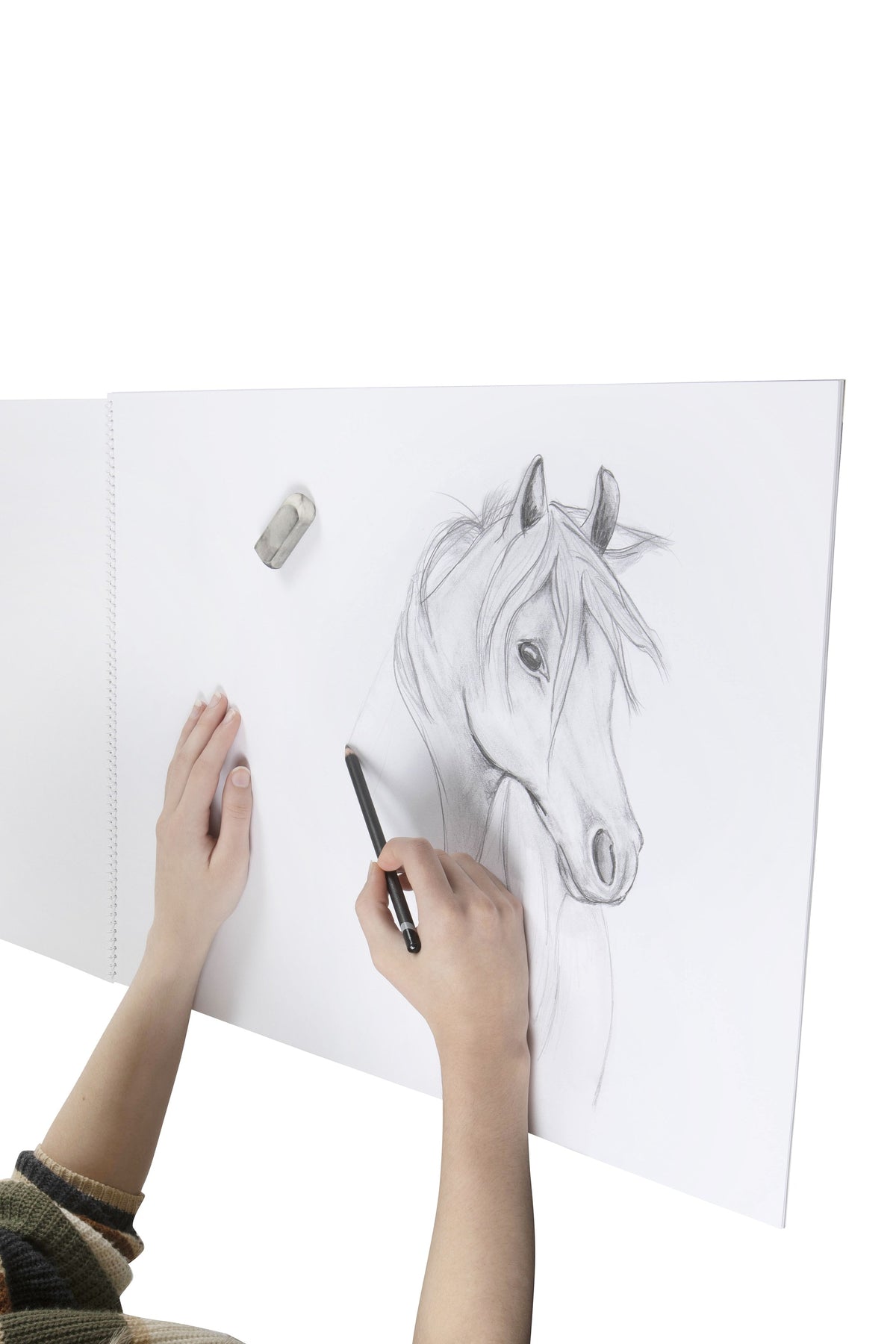 Pencil sketch of a horse head being drawn on a plain white page of the Spirax 532 A2 sketch book, with an eraser resting on the paper