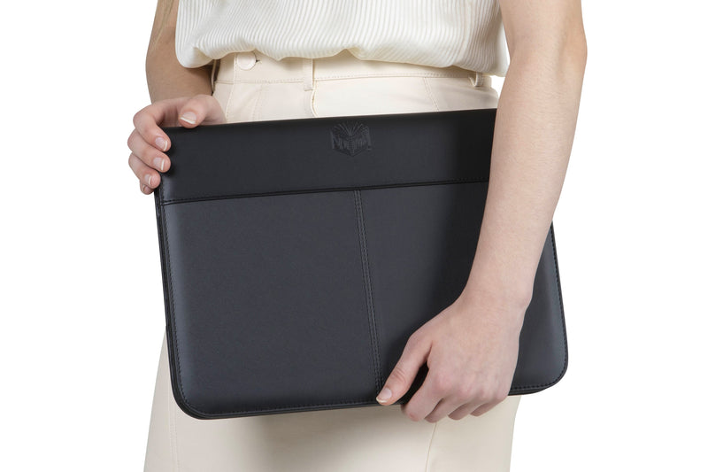 Closed black Spirax slimline compendium held flat under a person's arm, with the embossed Spirax logo on the top band