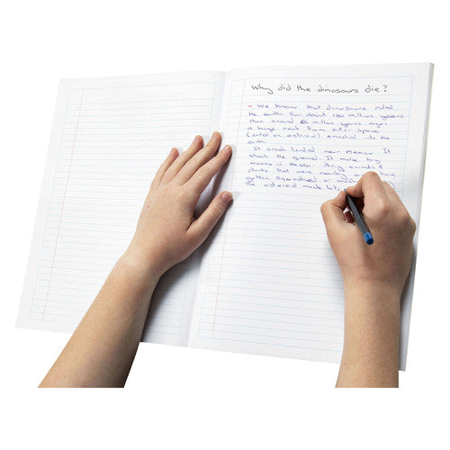 Student writing about dinosaurs in blue pen on the ruled pages of an open Spirax book, one hand holding the page flat