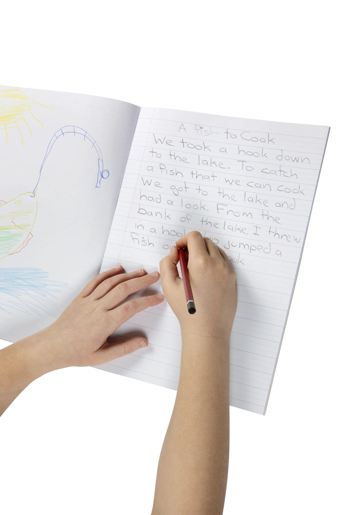 Child writing a story in pencil on the dotted thirds page of an open Spirax 162 writing book, with a drawing on the facing plain page