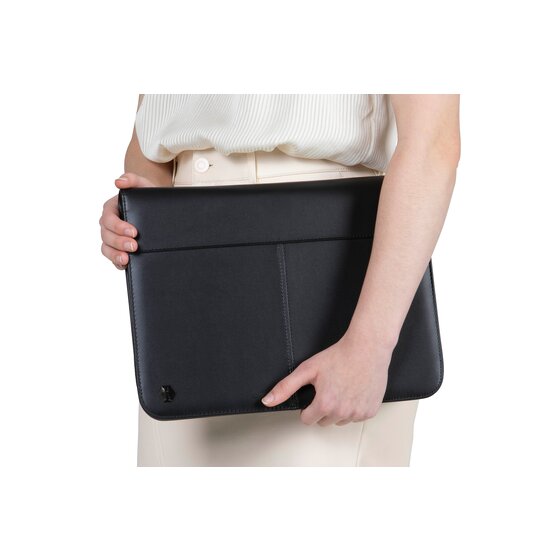 Person carrying the closed black A4 zippered compendium under one arm against a light background